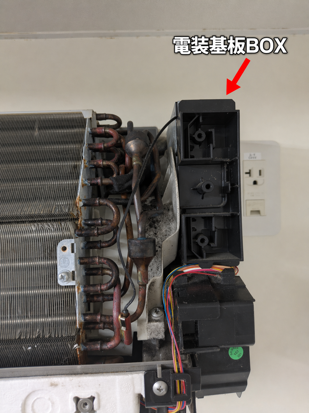エアコン側面パネルを開けた内部の様子。電装基板BOXの位置を赤い矢印で示している